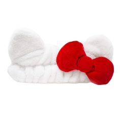 a red and white bow tie laying on top of a towel covered in fluffy yarn