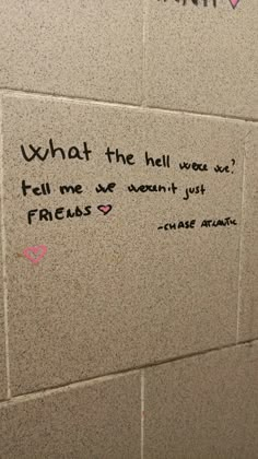 graffiti written on the wall next to a urinal