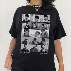 a woman wearing a black t - shirt with photos of young men on it