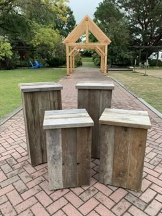 three wooden benches sitting on top of a brick walkway