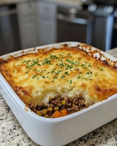 a casserole dish with meat and vegetables in it on a kitchen countertop