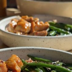 two white bowls filled with food on top of a table