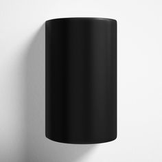 a black wall mounted light on a white wall