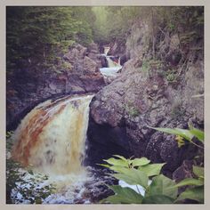 a large waterfall in the middle of a forest