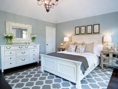 a bed room with a neatly made bed and a chandelier