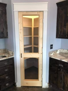 an empty bathroom with wooden cabinets and marble counter tops on the floor, in front of blue walls