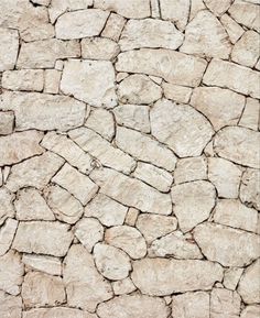 a stone wall that looks like it has been made out of rocks and is white