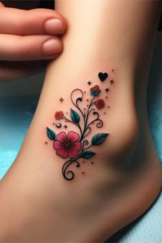 a woman's foot with flowers and hearts tattoo on the side of her leg