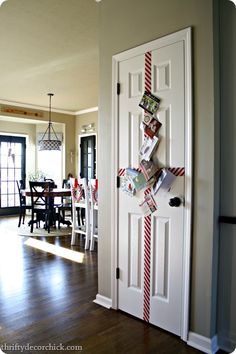 the door is decorated with red and white striped ribbon strips, which are hanging on the wall