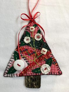 an ornament made out of fabric with buttons and ribbon hanging from the top