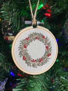 a cross stitch ornament hanging from a christmas tree