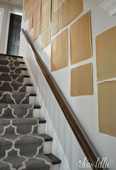 a stair case with pictures on the wall and carpeted steps leading up to it