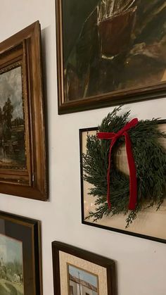 the wall is decorated with pictures and wreaths