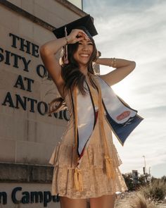 a woman in a graduation cap and gown posing for the camera with her hat on