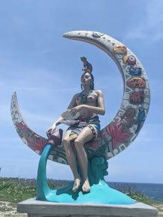 a statue of a woman sitting on the moon