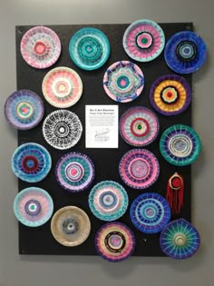 an art piece with many different colored plates on it