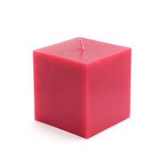 a red candle sitting on top of a white surface