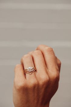 a woman's hand with a diamond ring on her left hand and the other hand holding