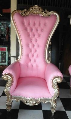 a pink chair sitting on top of a checkered floor