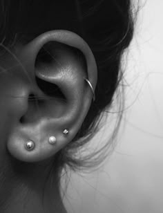 a woman's ear with two piercings on it