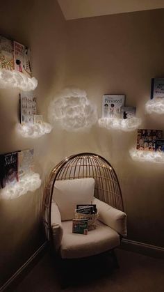 a wicker chair sitting in front of a wall with books and clouds on it