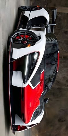 a red and white sports car hanging on the side of a building