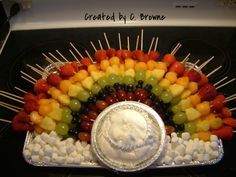 there is a platter with fruit and skewers in the shape of a buddha