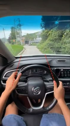 a person driving a car with their hands on the steering wheel and two red arrows pointing to