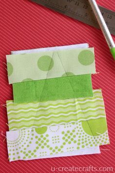 some fabric and scissors are laying on the table next to each other with green polka dots