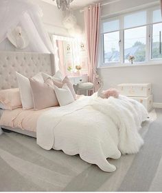 a white bed sitting in a bedroom next to a window