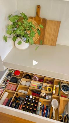 an organized drawer with scissors, tape and other crafting supplies in it on a counter top