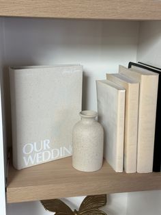 a book shelf with books and a vase on it