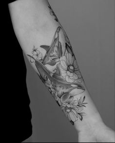 a black and white photo of a person's arm with flowers on it