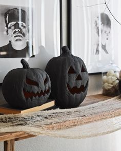 two carved pumpkins sitting on top of a table