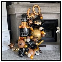 a birthday balloon tower with balloons and confetti in front of a fire place