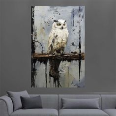 an owl is sitting on a branch in front of a gray wall with black and white paint