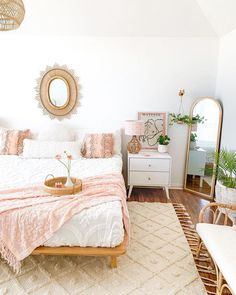 a bed room with a neatly made bed and a mirror on the wall above it