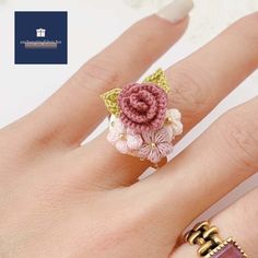 a woman's hand wearing a ring with flowers on it