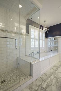 a large bathroom with a walk in shower next to a bathtub and two sinks