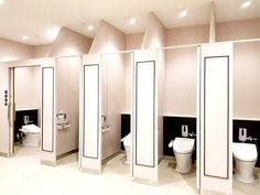 a row of stalls in a bathroom with toilet and urinals on the walls