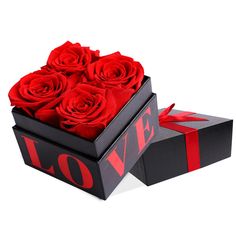 a black box with red roses in it and the word love is written on top