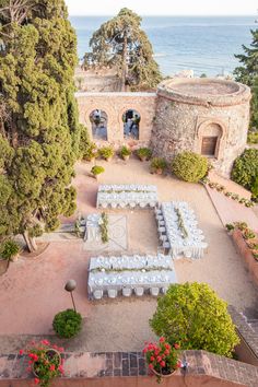 an aerial view of a wedding venue with tables and chairs set up in front of the ocean