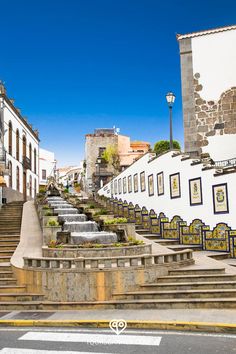 an empty street with steps leading up and down to some buildings on the other side