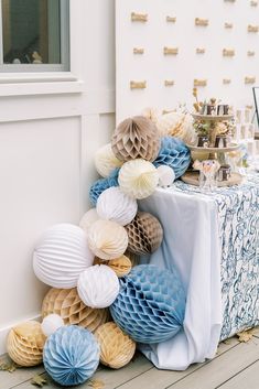 a table topped with paper honeycombs on top of a wooden floor next to a white wall