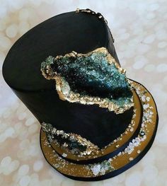 a black hat with gold and green decorations on it