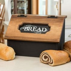 bread rolls sitting on top of a counter next to a wooden box with the word bread written on it