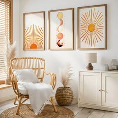 three framed pictures hang on the wall above a wicker chair