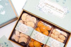 an open box filled with oranges and cookies