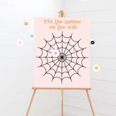 an easel with a spider on the web sign in front of white walls and floor