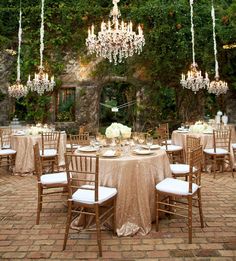 an outdoor dining area with chandeliers and tables set up for a formal function